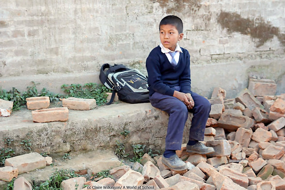Nepalese boy sits in earthquake rubble