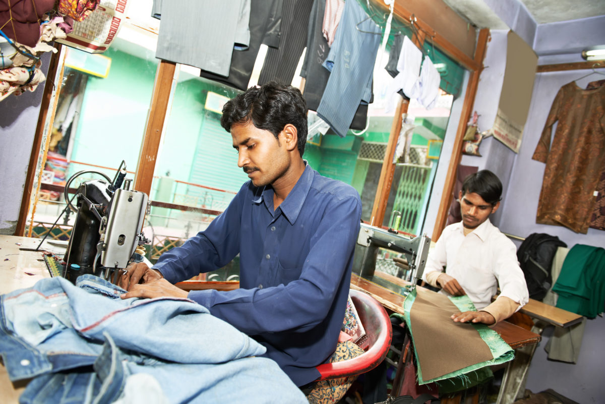 Young South Asian man working in on a sewing machine.